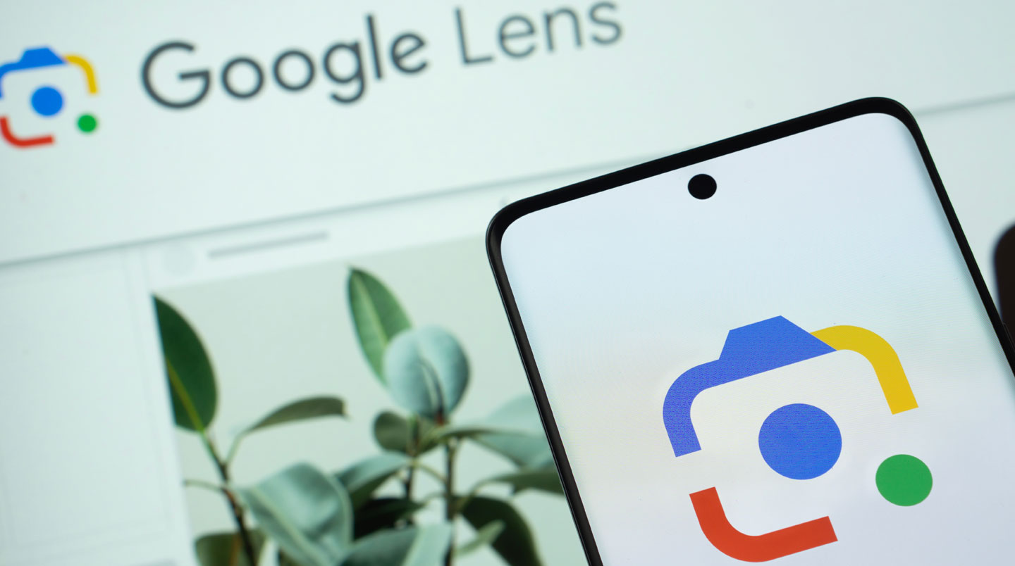 Smartphone affichant Google Lens prêt à analyser un objet en arrière-plan.
